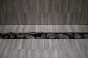 Tiled floor strip with decorative stones
