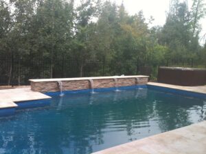 Pool with stone wall & water spouts