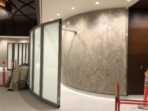 Construction site featuring glass partitions, a curved wall, and safety barriers.